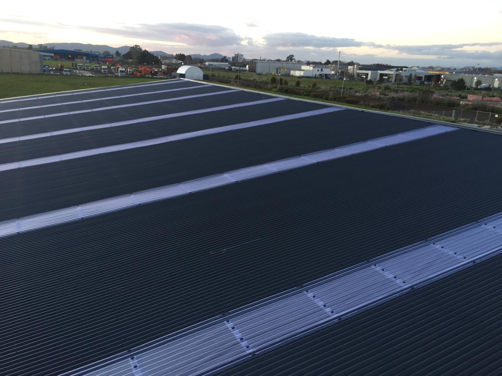 Large commercial long-run roof at dusk