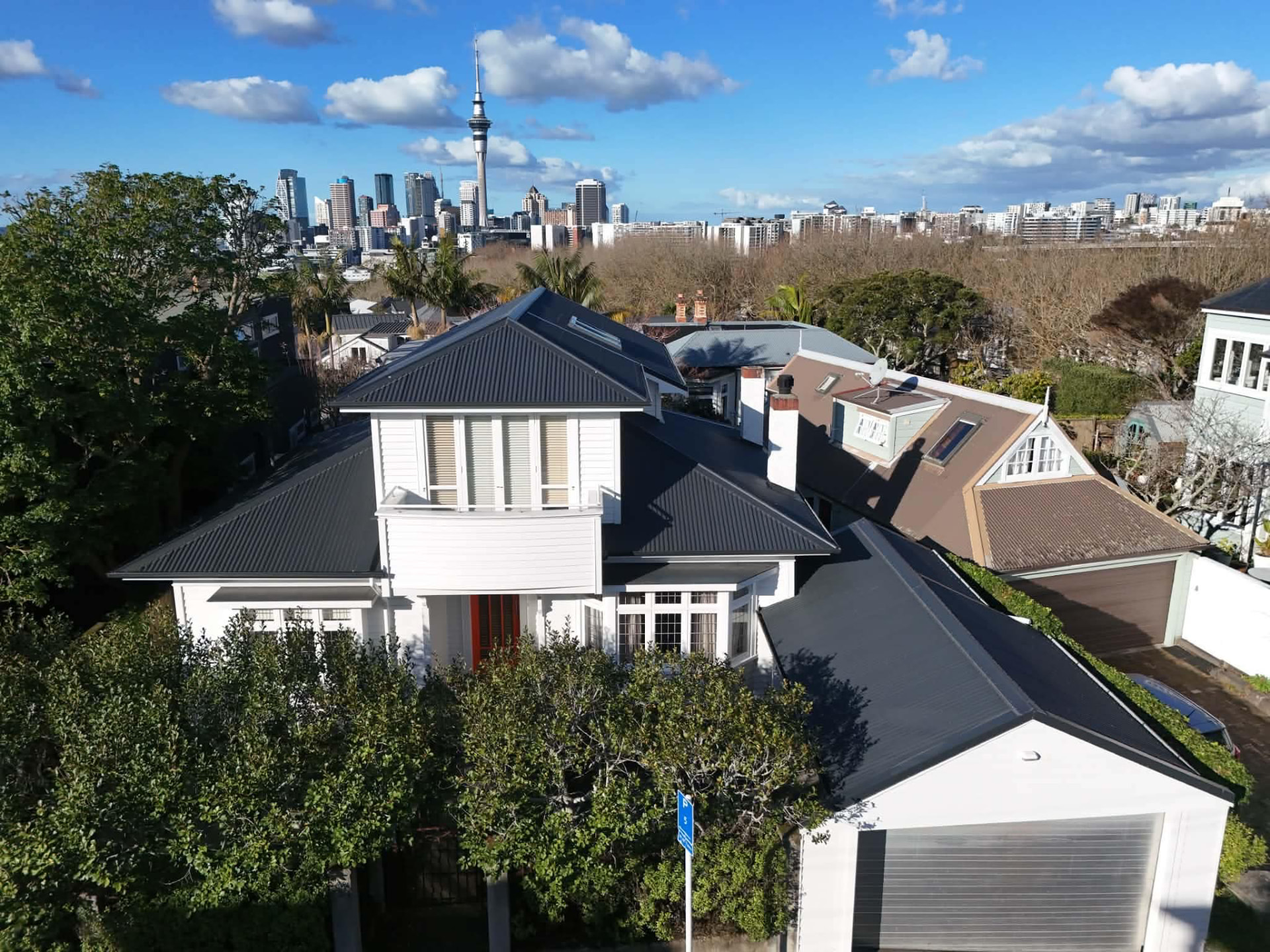 Aerial view of a large Auckland home with a new charcoal long-run steel roof