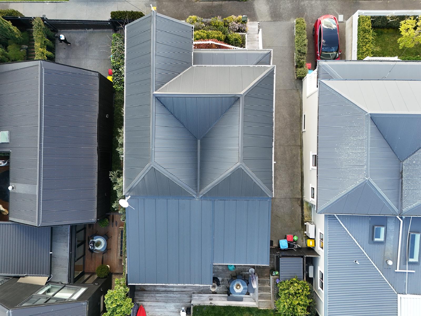 Aerial view of modern townhouses with new grey long-run steel roofing and cladding