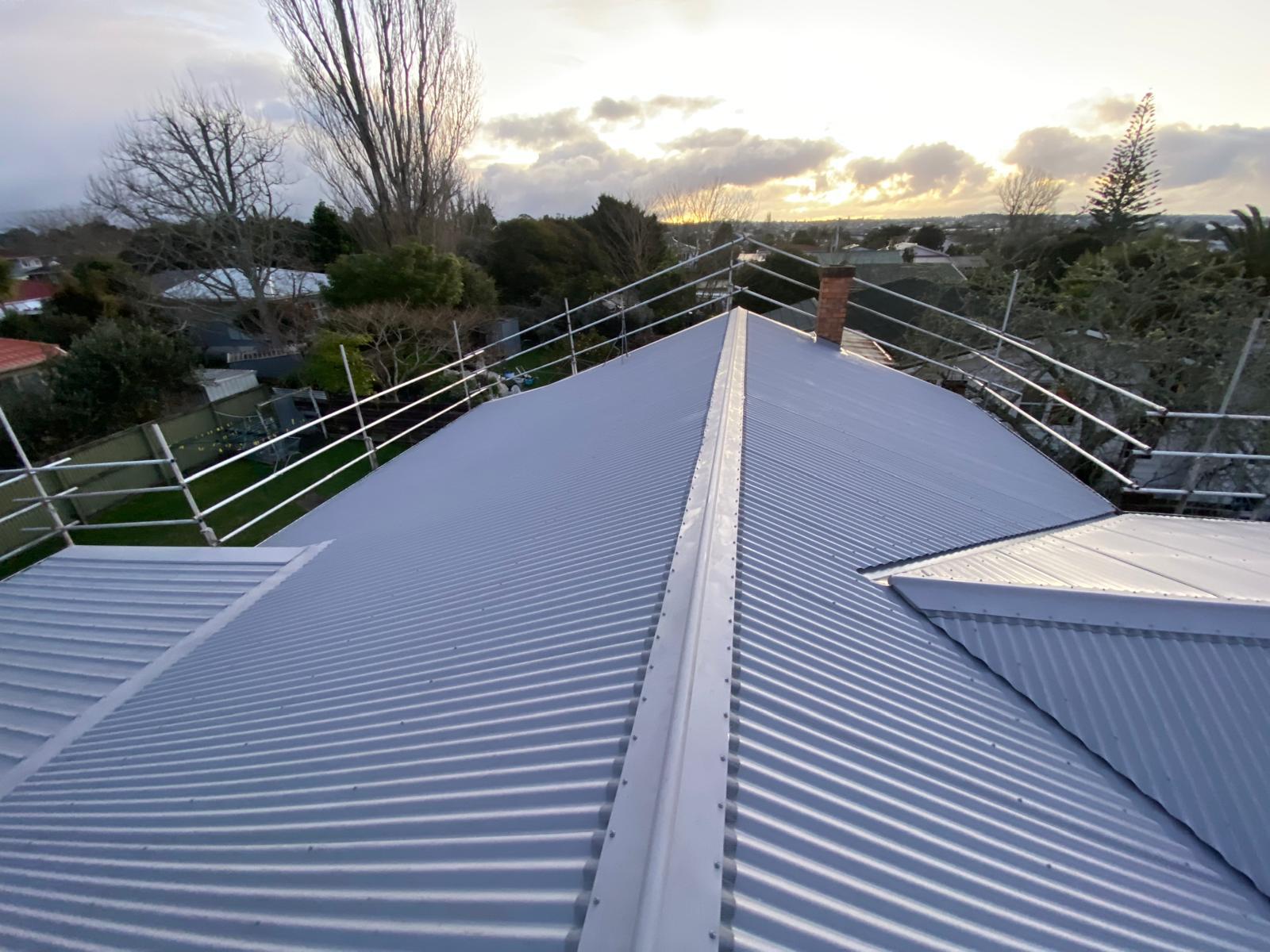 Grey residential roof and ridge at sunset