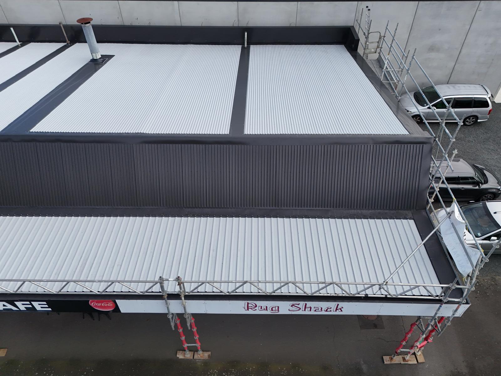 New long-run roofing and dark corrugate parapet cladding on a commercial building