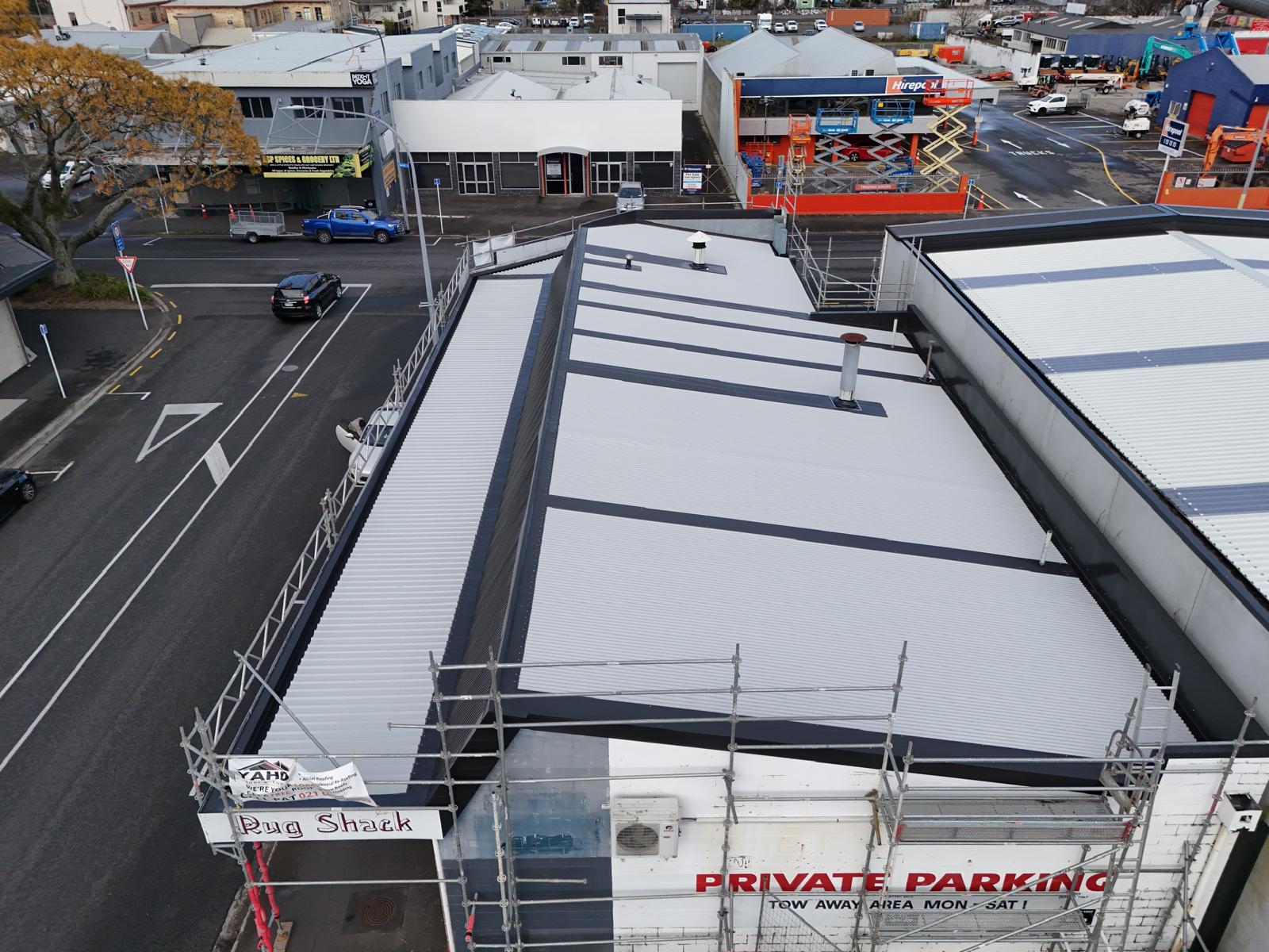Aerial view of a completed retail commercial re-roof with scaffold in place