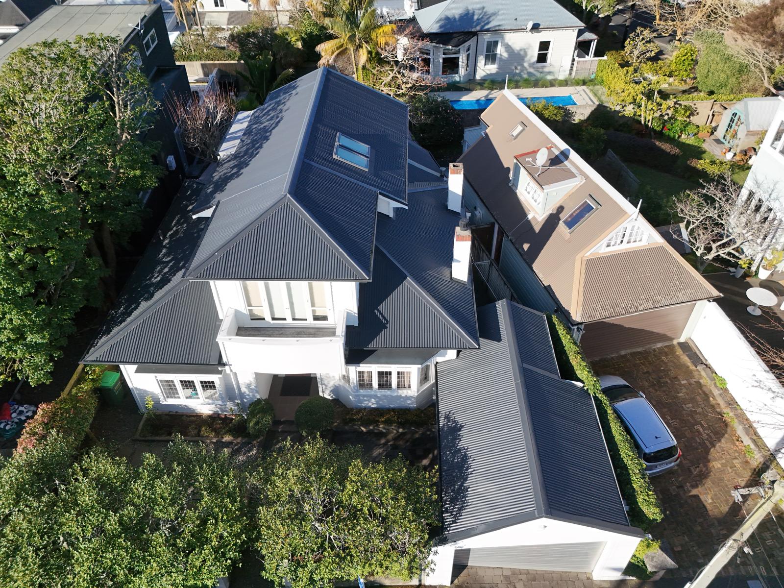 Aerial view of a completed charcoal long-run roof across a large character home