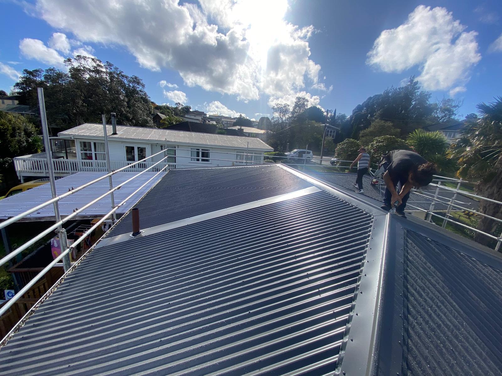 YAHD crew installing long-run roofing on a sunny day