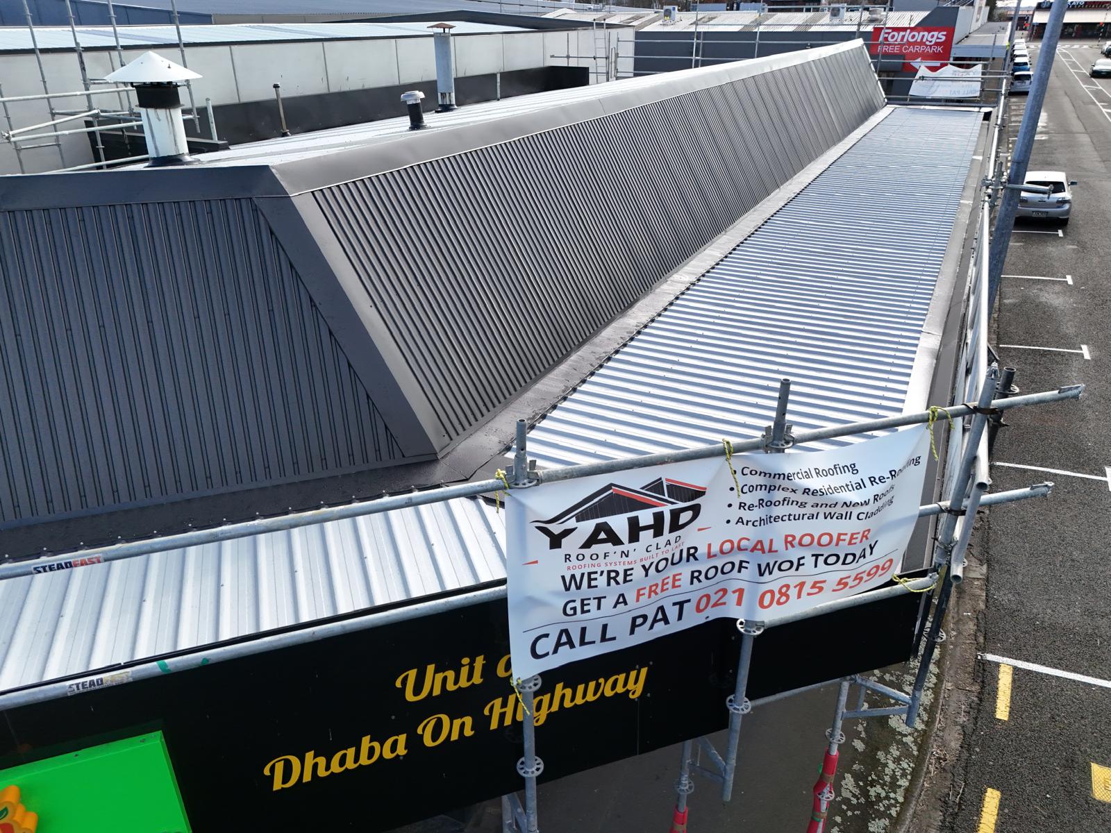 Commercial re-roof in progress with YAHD site signage on the scaffold
