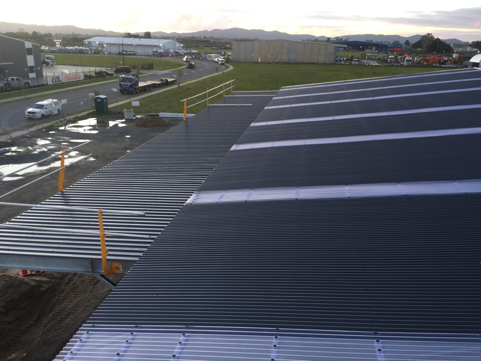Ridge line of a large dark commercial roof at dusk